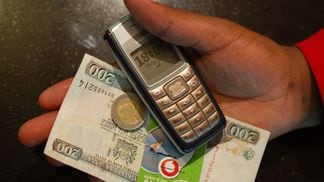 Mobile Phone with Money in Kenya / Flickr / whiteafrican