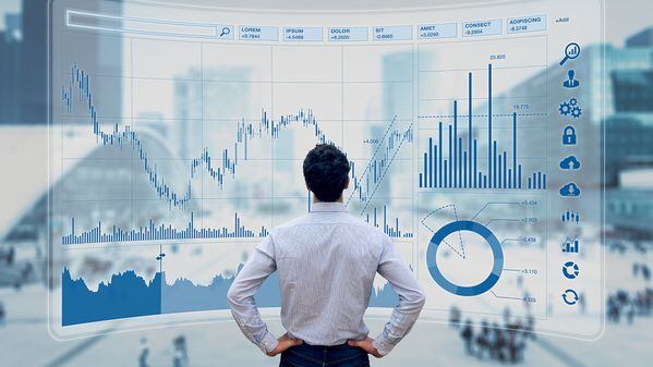 Finance trade manager analysing stock market indicators for best investment strategy, financial data and charts (Getty Images)