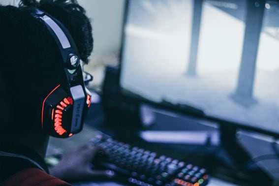 Gamer in headphones playing a video game on a PC console