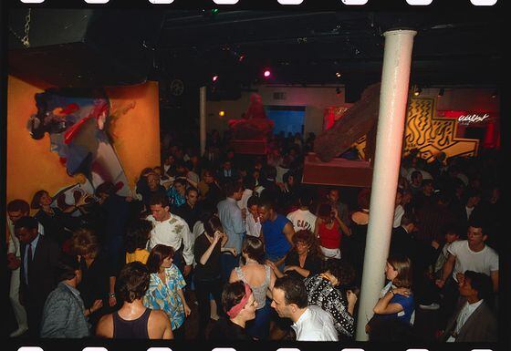A crowd dances at Area nightclub decorated with paintings by artist Keith Haring.   (Photo by Nick Elgar/Corbis/VCG via Getty Images)