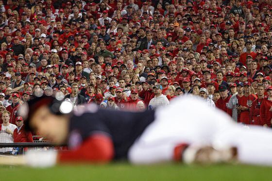 Fans react as Ryan Zimmerman #11 of the Washington Nationals reacts after nearly being hit by the pitch against the Houston Astros during the fifth inning in Game Three of the 2019 World Series at Nationals Park on October 25, 2019 in Washington, DC.