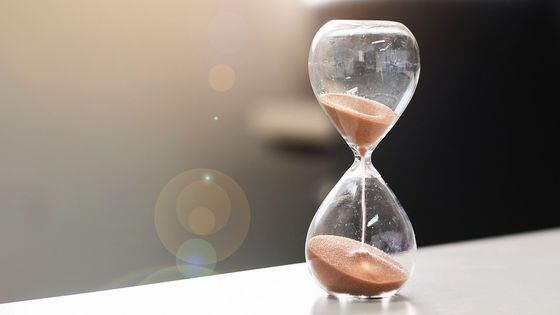 Hourglass on table office with copy space, Sand flowing through the bulb of Sandglass measuring the passing time. countdown, deadline, Life time and Retirement concept (Getty Images)