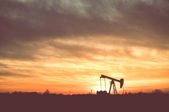 Silhouette of an oil derrick during sunset
