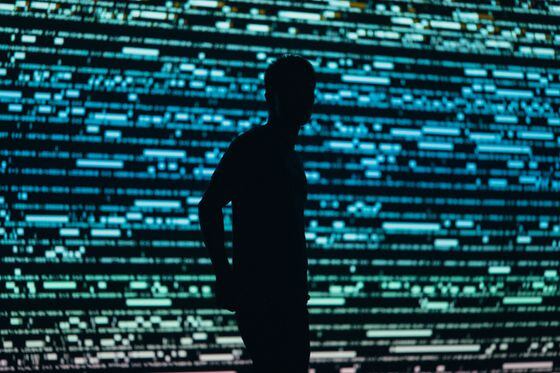 Silhouette of a man in front of a backdrop of code/data.