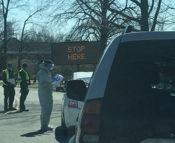 IN-N-OUT: Workers in hazmat suits greet visitors to the drive-through coronavirus testing facility in New Rochelle, N.Y., before sticking swabs up their noses. (Photo by Michael J. Casey)