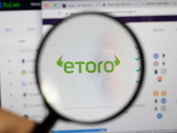 Magnifying glass over Etoro logo