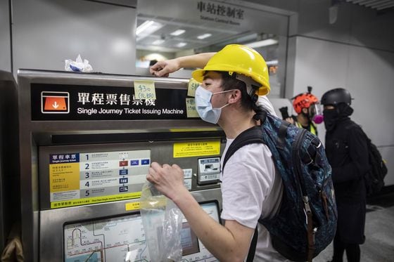 A demonstrator collects Hong Kong dollar coins for fellow protesters to purchase subway tickets, 2019. 