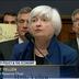 Christian Langlais holds up a "Buy Bitcoin" sign behind Federal Reserve Chair Janet Yellen at a House Financial Services Committee hearing in July 2017. (C-Span)
