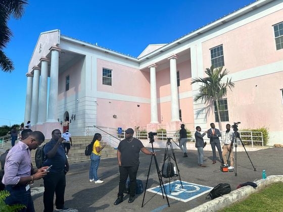 Members of the press assemble before the pink-hued Magistrate Court in Nassau in anticipation of Bankman-Fried's arrival. (Cheyenne Ligon/CoinDesk)