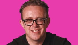 headshot of Nick Jones against bright pink background