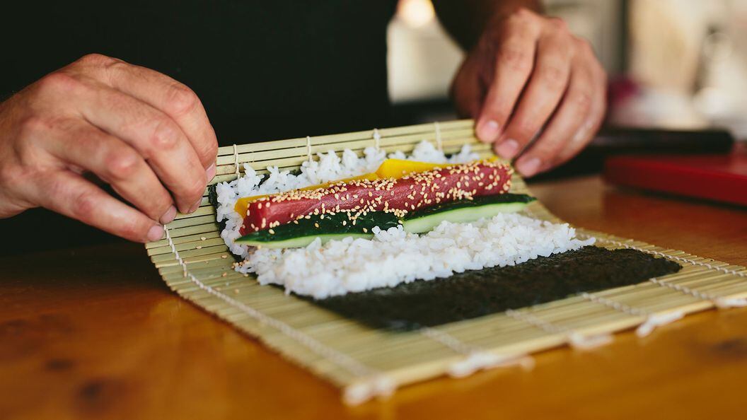 Faceless view of chef rolling sushi with makisu...</p>
</div>
<div class=