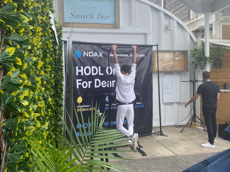 A participant attempts the dead hang for an opportunity to win $1,000 in bitcoin. (Margaux Nijkerk/CoinDesk)