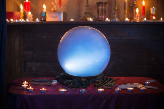 Magic crystal ball with burning candles on  table
