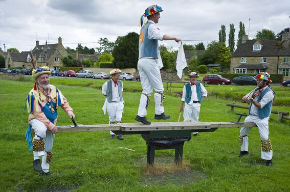 Morris Dancers on a seesaw in the Cotswolds, U.K.