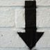 Down Arrow spray painted on a brick wall (Shutterstock)