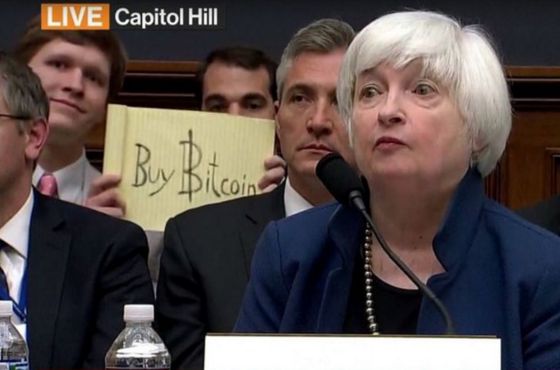 The infamous "buy bitcoin" sign behind then-Fed Chair Janet Yellen as she testified on Capitol Hill.