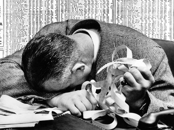 CDCROP: 1940s MAN HEAD ON DESK Trader Ticker Tape Stocks Wall Street (Armstrong Roberts/ClassicStock/Getty Images)