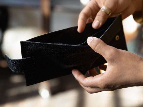 Hands of young African woman opening empty black wallet