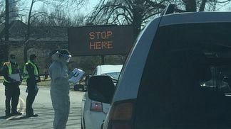 IN-N-OUT: Workers in hazmat suits greet visitors to the drive-through coronavirus testing facility in New Rochelle, N.Y., before sticking swabs up their noses. (Photo by Michael J. Casey)