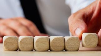 CDCROP: Businessman placing six blank wooden dices in a row (Gajus/iStock/Getty Images Plus)