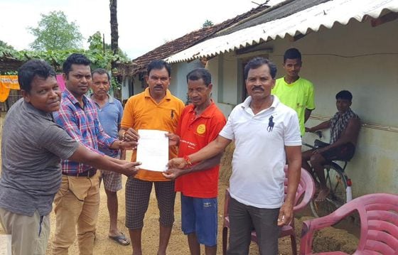 Indian government officials hand a paper copy of a caste certificate with a QR code linking to its blockchain original to a tribal person in a village in the Etapalli subdivision of district Gadchiroli, Maharashtra. (Shubham Gupta)