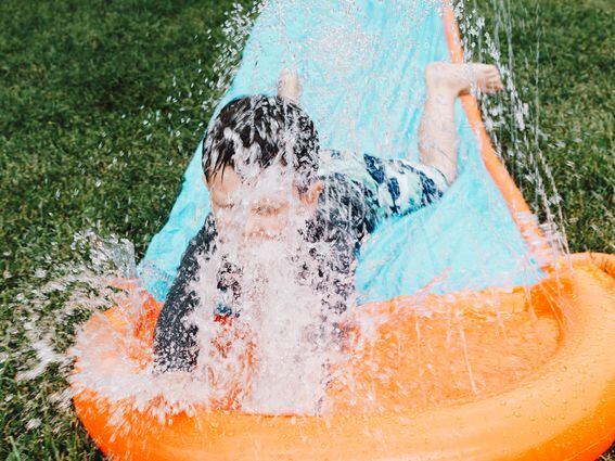 CDCROP: Kid slides on a slip and slide to a splash (Kelly Sikkema/Unsplash)