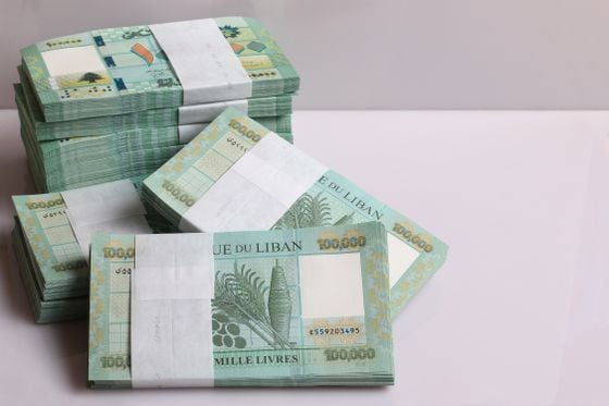 Stacks of Lebanese pounds, 100,000 denomination, symbolizing the downfall of the Lebanese currency.
