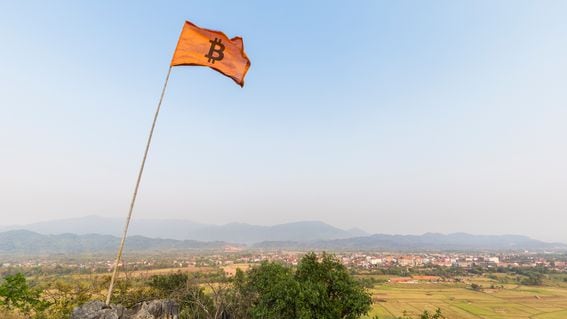 Flag fluttering atop the Pha Poak hill with a bitcoin symbol, representing Bitcoin's price and it's win over banks.