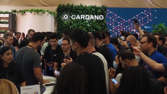 A crowd looks past the Cardano booth at Consensus 2022 (Danny Nelson/CoinDesk)