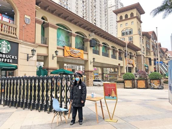 A guard polices access to a shopping area in Wuhan. (Credit: Shutterstock)