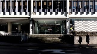 Pedestrians walk past the Reserve Bank of New Zealand headquarters in Wellington. (Birgit Krippner/Bloomberg via Getty Images)
