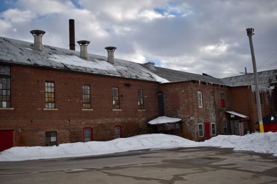 Photo of a brown-brick warehouse. Photo is taken from the back side of the building.
