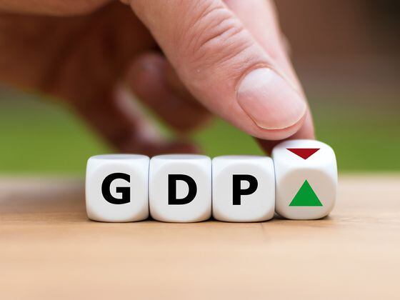 CDCROP: Hand is turning a dice and changes the direction of an arrow symbolizing that the GDP of a country is changing the trend and goes up instead of down (or vice versa) (Getty Images)