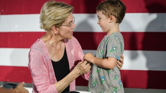 Elizabeth Warren in front of an American flag with child