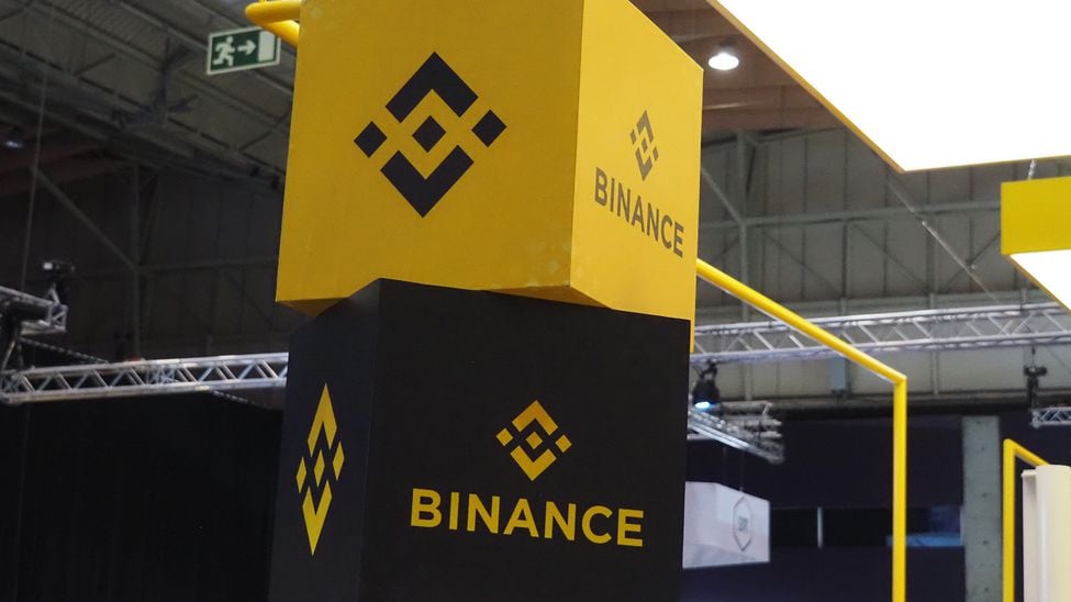 Bir ticaret fuarında Binance'in logosunu gösteren iki büyük yığılmış blok.