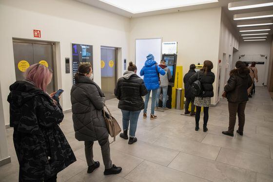Customers queue to use automated teller machines (ATM) inside a shopping mall in Moscow, Russia, on Thursday, Feb. 24, 2022. Russian banks are facing a wave of international sanctions after Russia's invasion of Ukraine.